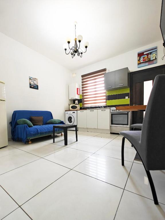ein Wohnzimmer mit einem blauen Sofa und einem Tisch in der Unterkunft Corner view 3 in Marsaskala