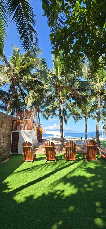 a group of chairs sitting on the grass near the beach at J's PALM BEACH Resort in Batangas City