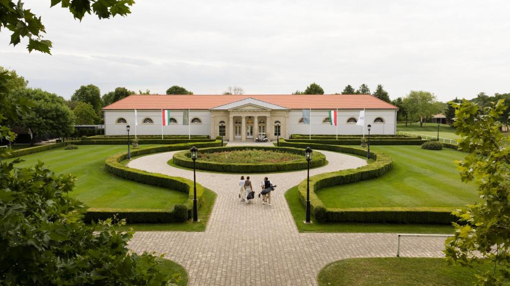 a house with two people riding horses in front of it at Pannónia Golf & Country Club in Alcsútdoboz