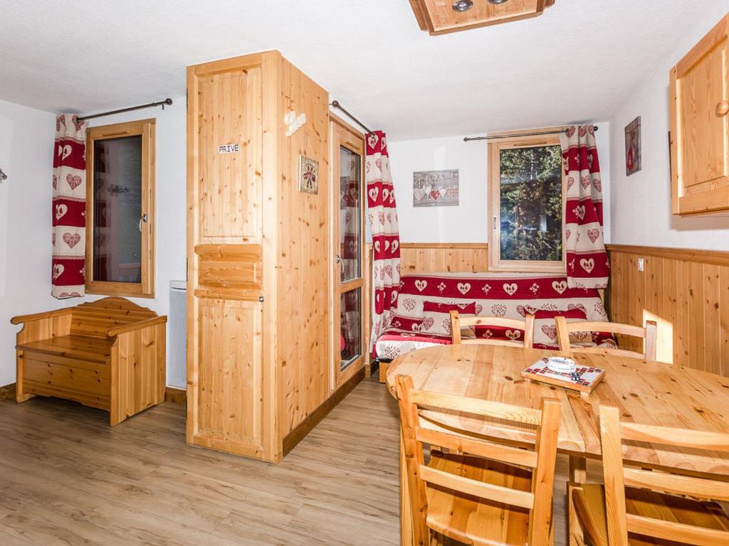 a kitchen and dining room with a wooden table and chairs at Studio rénové à Montchavin La Plagne, proche pistes et commerces, balcon, casier à skis, parking gratuit - FR-1-329-28 in Bellentre