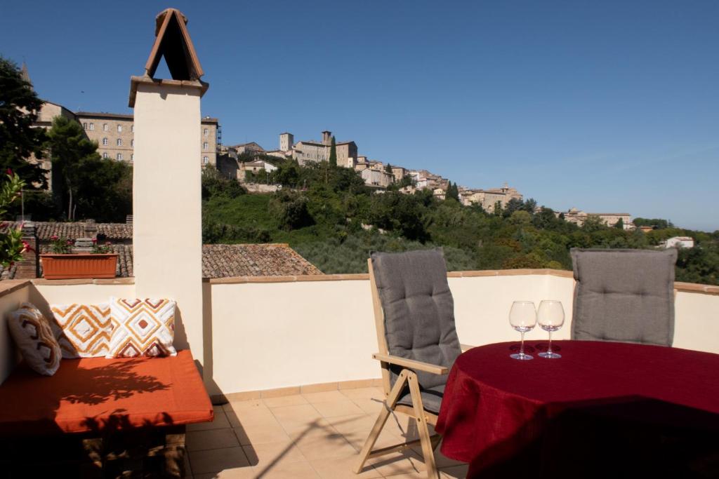 a table and two chairs with wine glasses on a balcony at Terrazza Mira - Vista panoramica e parcheggio a Todi in Todi