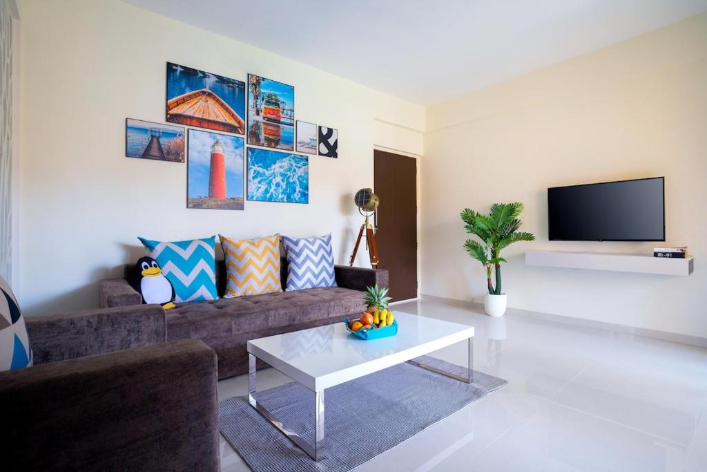 a living room with a couch and a table at Nayaab by Leo Homes - 2BHK Flat near Anjuna Beach in Anjuna
