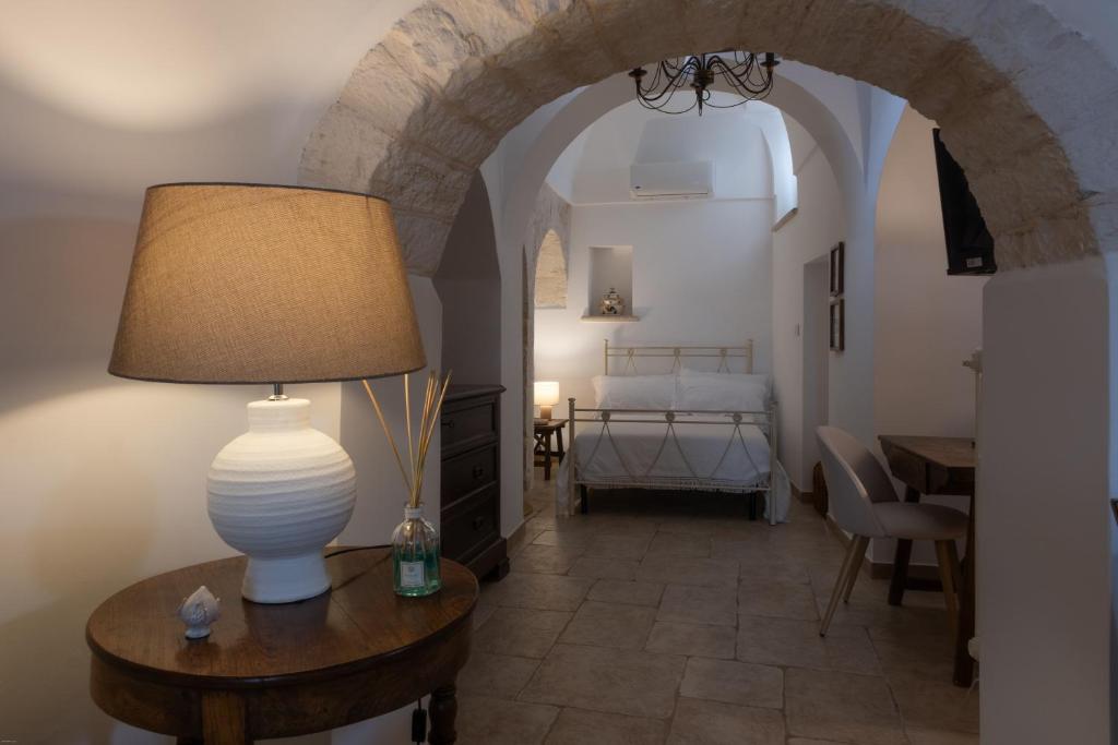 a room with a lamp on a table with a bedroom at Trulli Suite 34 in Alberobello