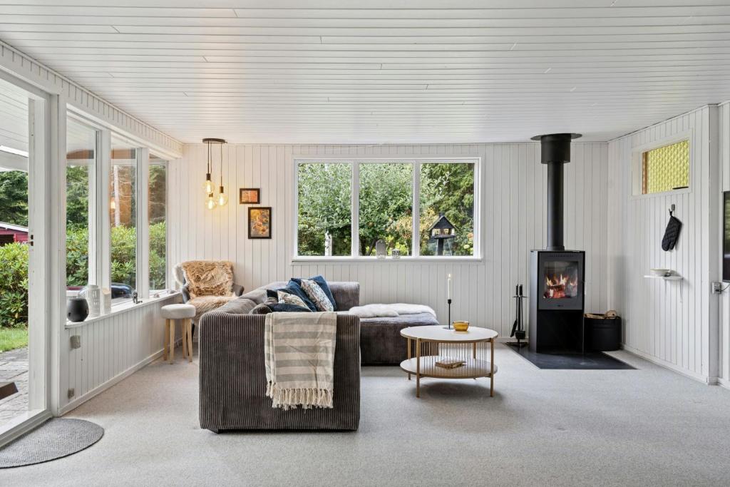 a living room with a couch and a fireplace at Holiday Home With Creative Space Near Glesborg in Glesborg