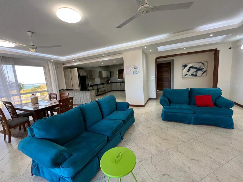 a living room with a blue couch and a table at Antalya Epic stays in Mombasa