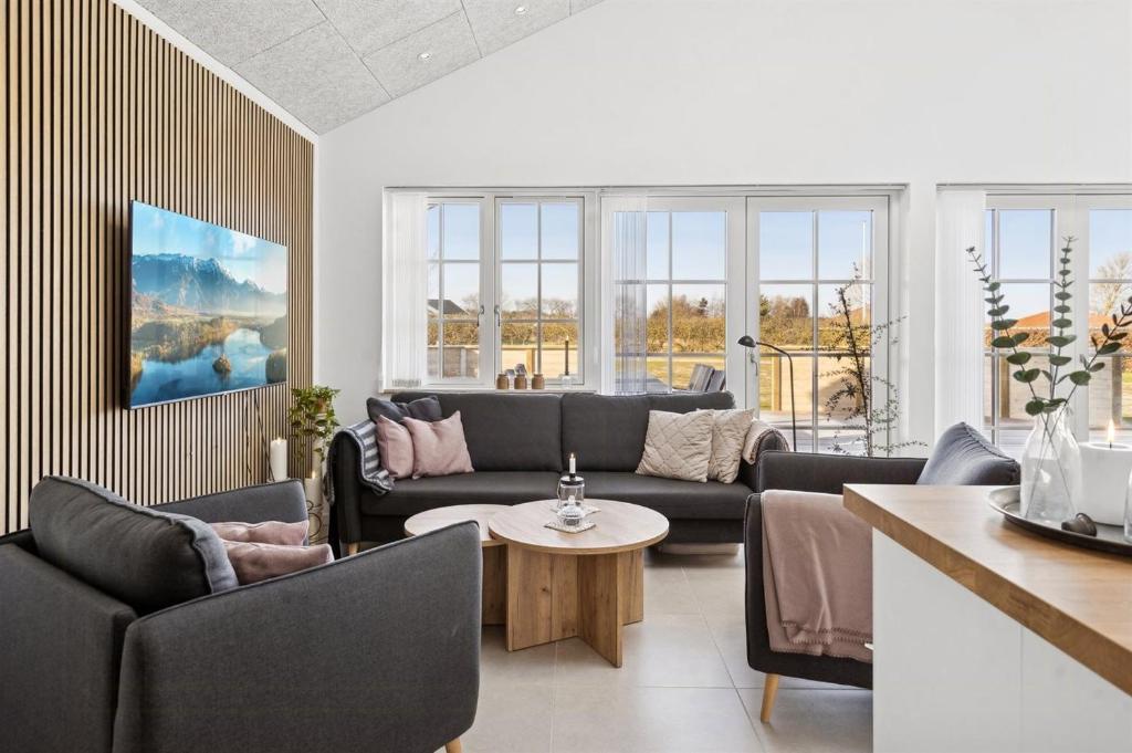 a living room with couches and a table at Modern Family House Near Købingsmark Beach in Nordborg