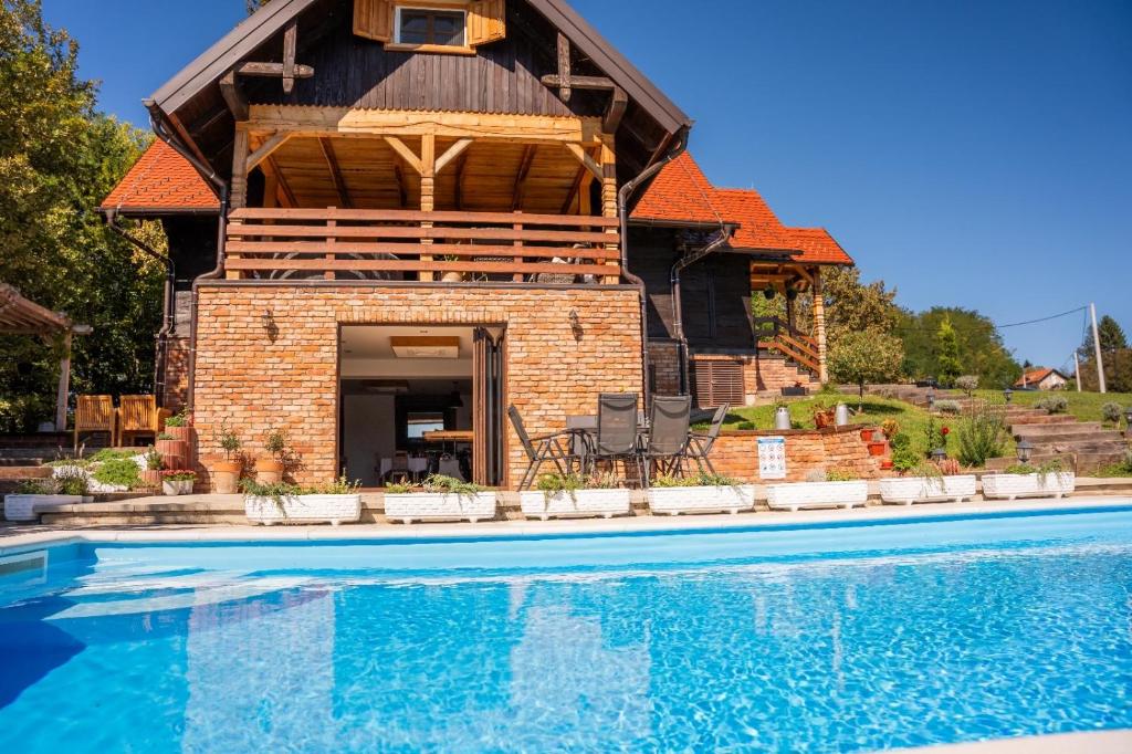a house with a swimming pool in front of it at Tri srca in Pisarovina