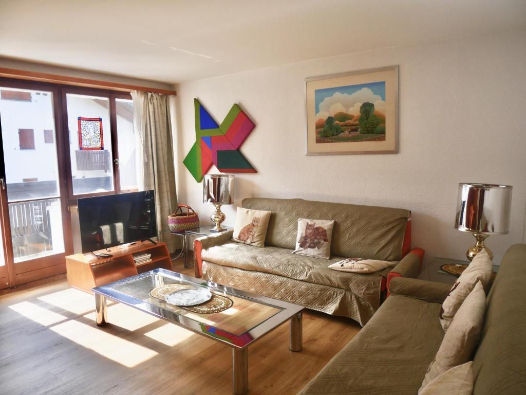 a living room with a couch and a table at Chesa Chatrigna App 6 - Celerina in Celerina