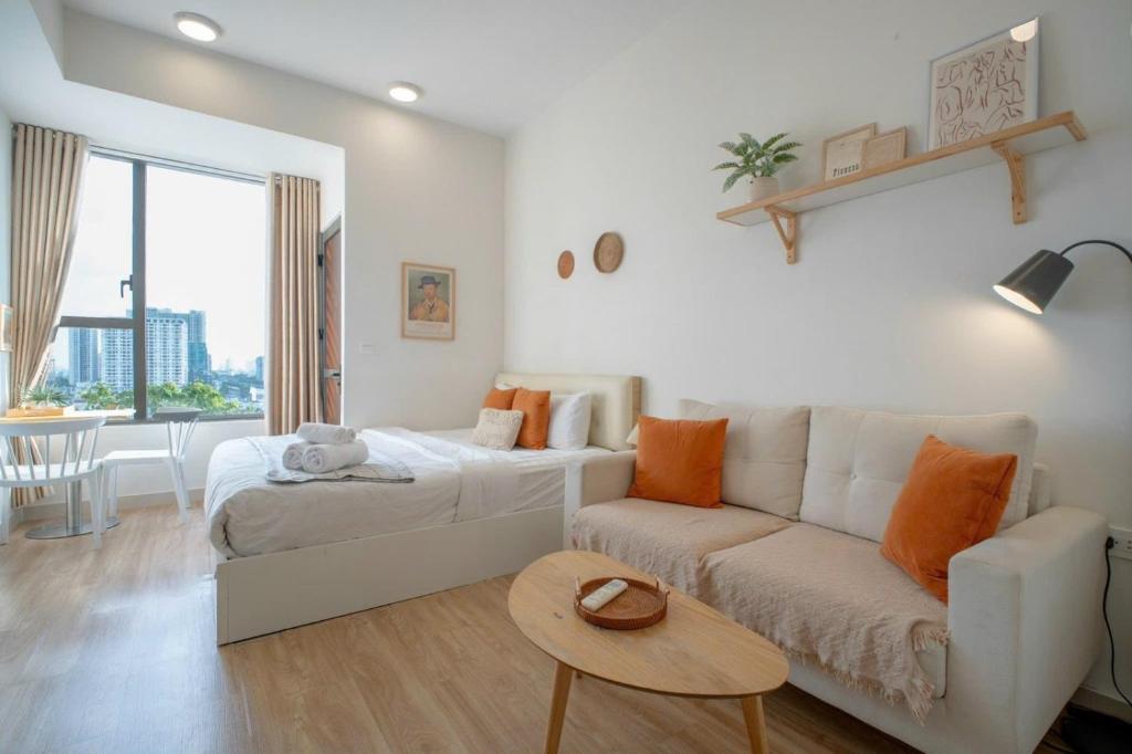 a living room with a couch and a bed and a table at DFour River Gate Deluxe Apartment by the River in Ho Chi Minh City