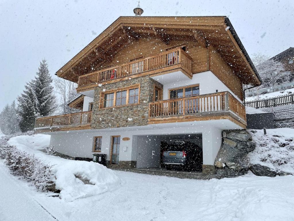 a house is covered in snow in the yard at Chalet in Mühlbach near Ski Slopes in Mühlbach am Hochkönig