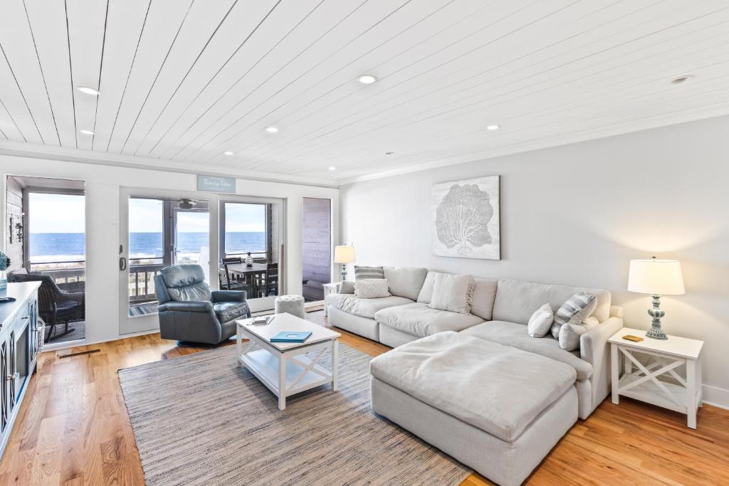 ein Wohnzimmer mit Sofa und Tisch in der Unterkunft Beach Club Villa 31 - Luxurious Oceanfront - Beach Walkout in Isle of Palms
