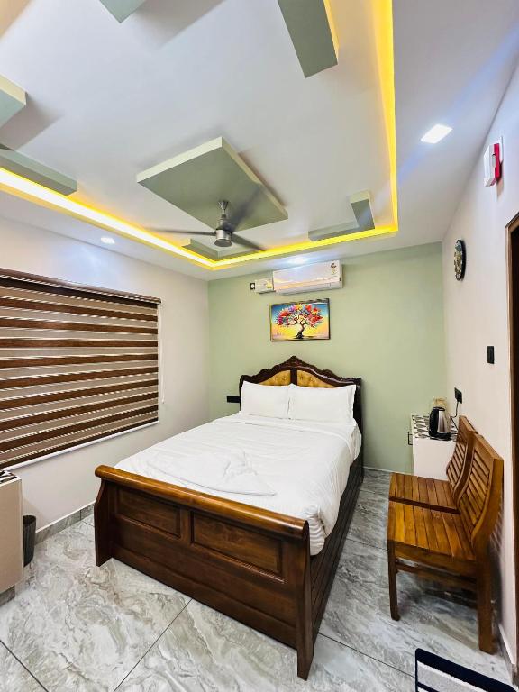 a bedroom with a large bed and a chair at North paradise in Cochin