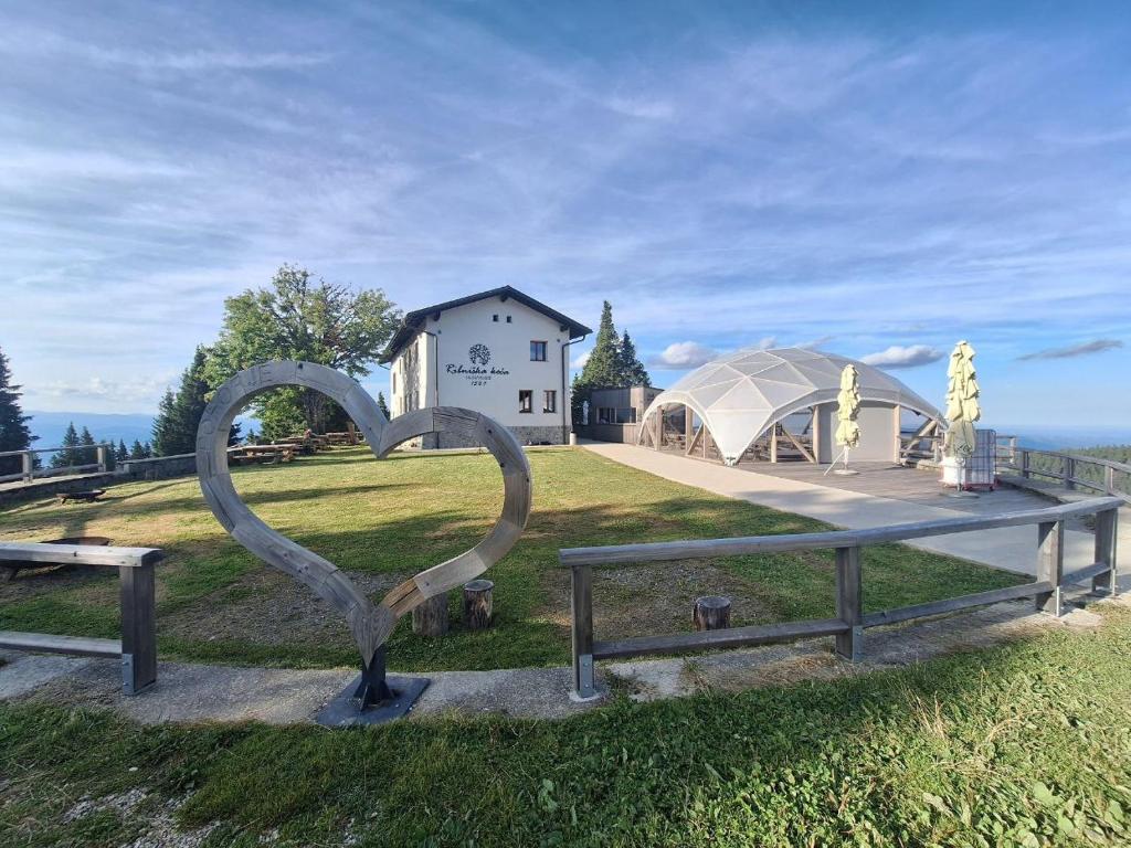 a sculpture of a heart in front of a building at Ribniška koča in Ribnica na Pohorju