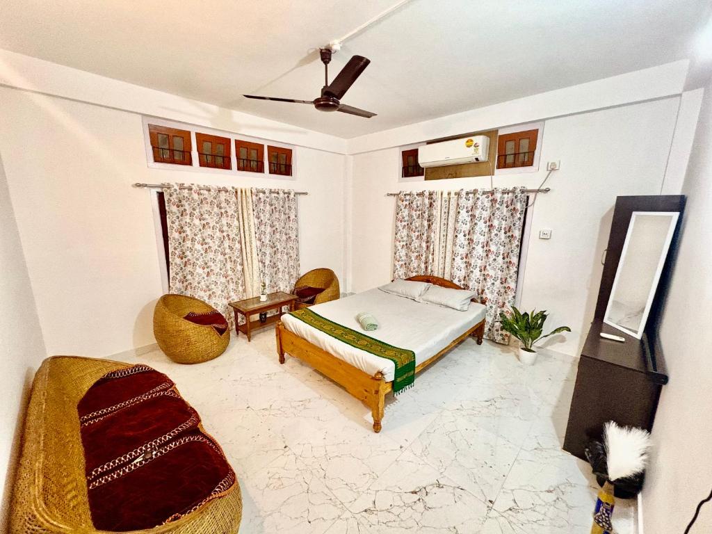 a bedroom with a bed and two chairs at Puspalay Homestay in Guwahati