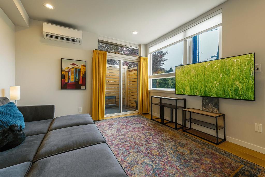 a living room with a couch and a flat screen tv at Perch - Wallingford Comfort in Seattle