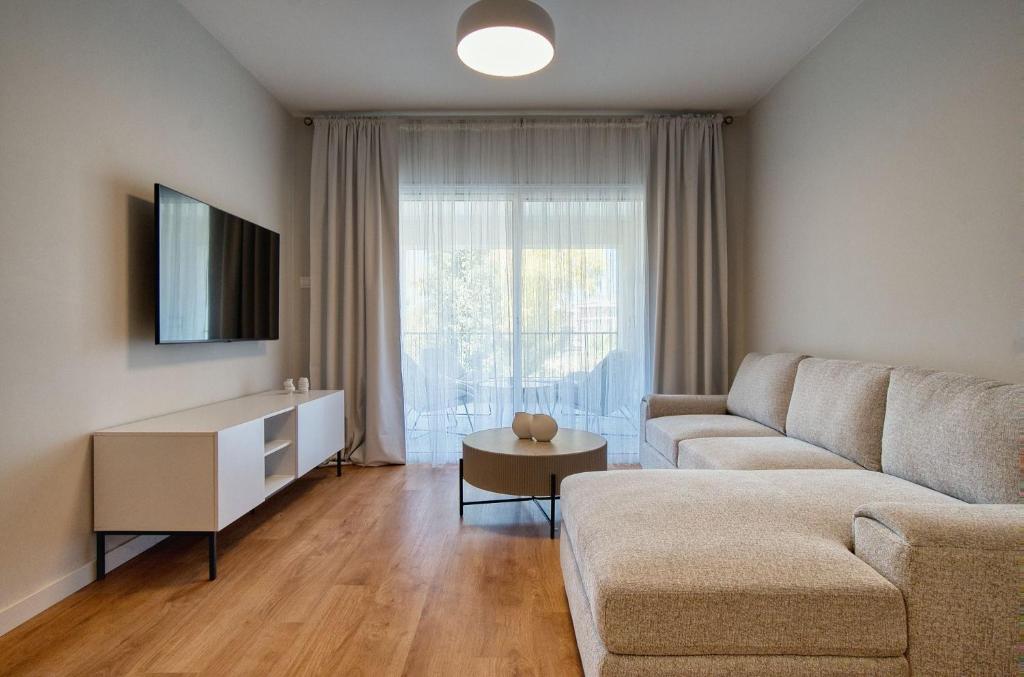 a living room with a couch and a table at Hesperides Gardens D203 in Ktima