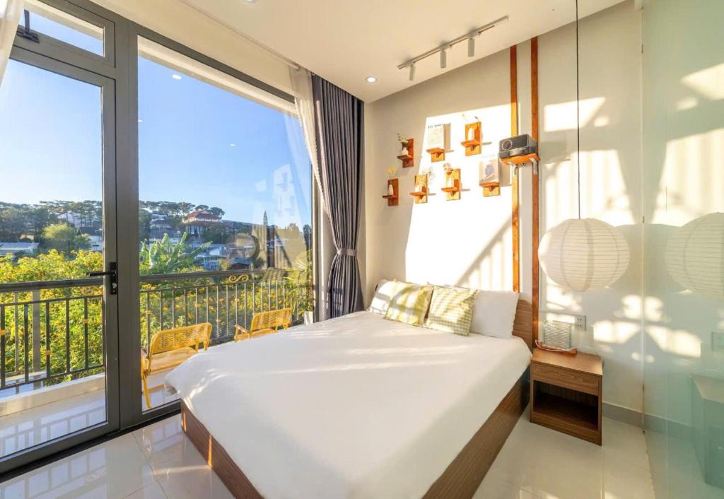 a bedroom with a bed and a large window at Happy Home Da Lat in Da Lat