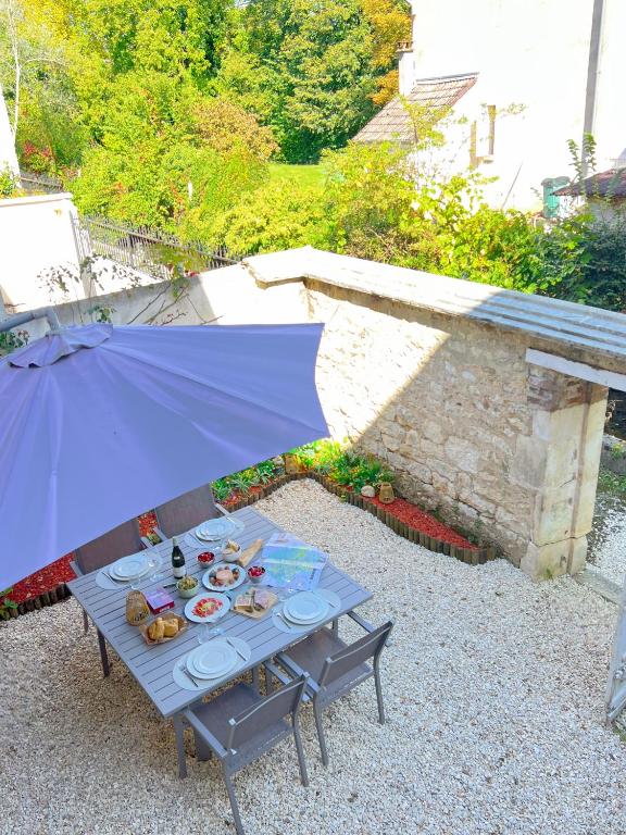 a table with plates of food and an umbrella at L'Ecrin de Chablis in Chablis