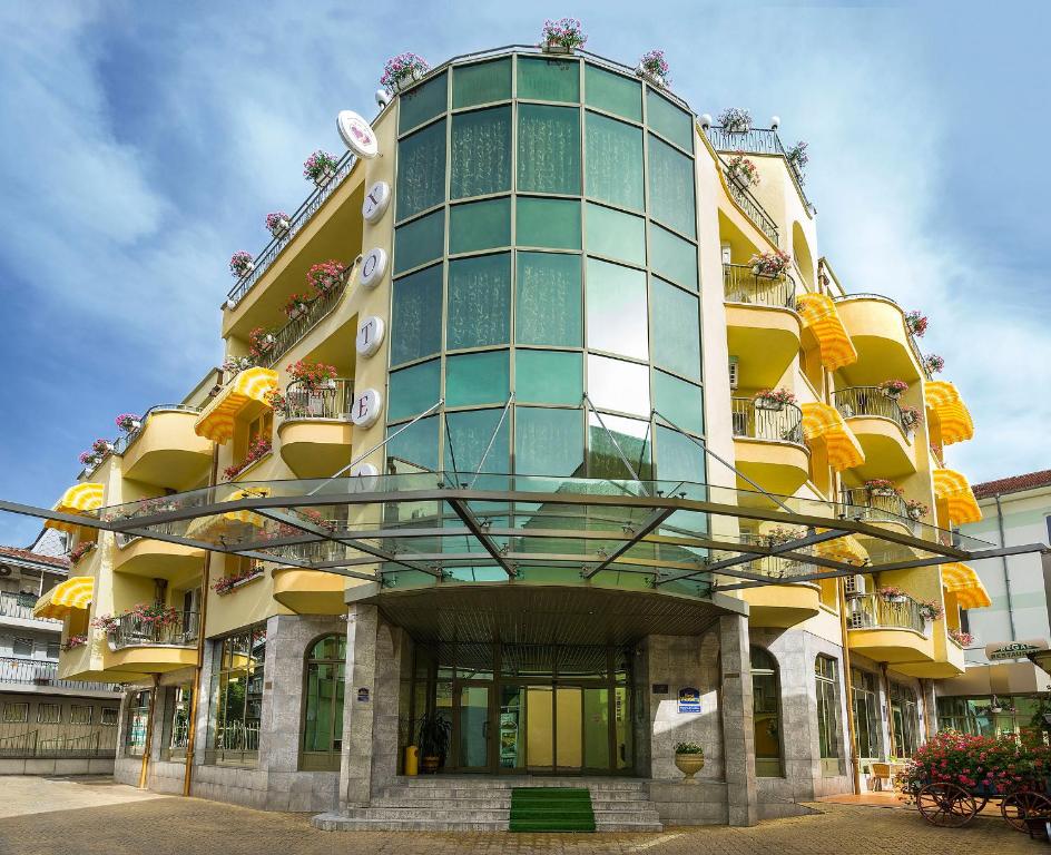 a tall yellow building with windows and balconies at Bistra & Galina Hotel in Ruse