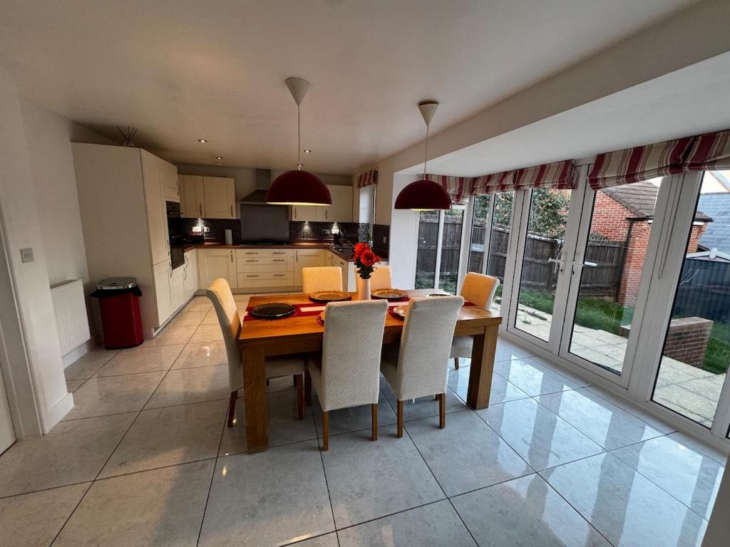 Norton FitzwarrenにあるCozy Stays Tauntonの木製のテーブルと椅子のあるキッチンとダイニングルーム