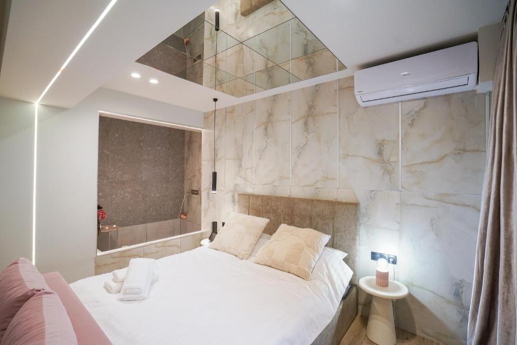 a bedroom with a white bed and a stone wall at Love room & Spa in Larisa