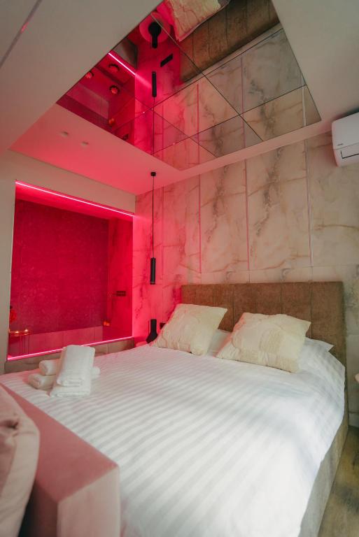 a bedroom with a large bed with red lighting at Love room & Spa in Larisa