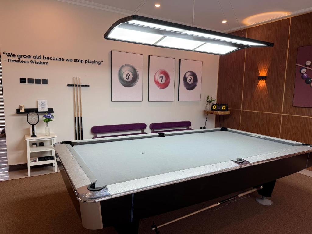 バンドンにあるThe Sakura House - Casa 99 Bandungの壁に絵画が飾られた部屋のビリヤード台