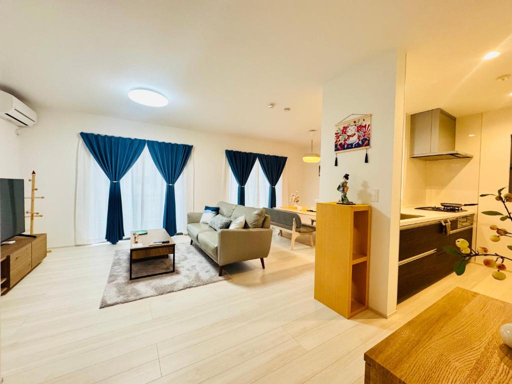 a living room with a couch and a table at 大阪りんくん新築Yutori蘭 in Izumi-Sano