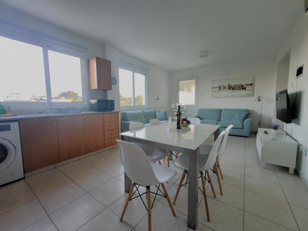 a kitchen and living room with a table and chairs at Pantelia Apartment Paralimni in Paralimni