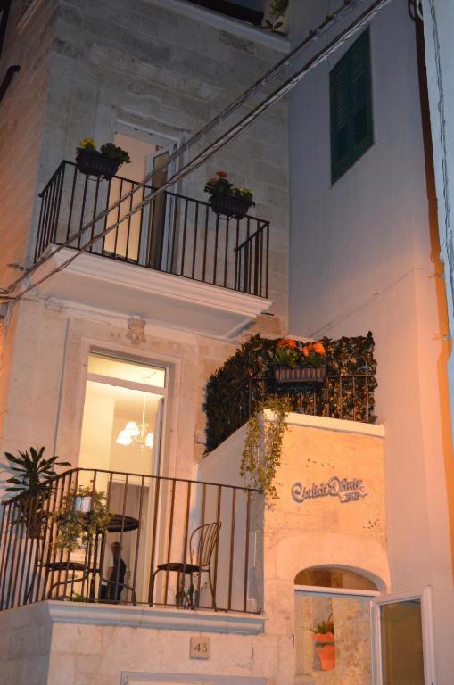 a building with potted plants on the balconies of it at dimore cieli di dante in Conversano