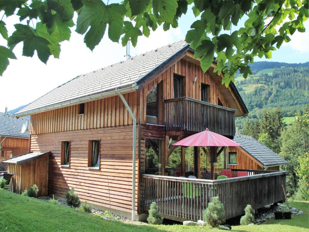 a wooden house with an umbrella in front of it at Chalet in St Georgen ob Murau nahe Skigebiet in Sankt Georgen ob Murau