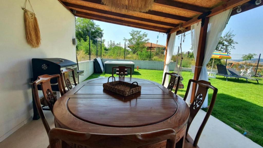Una mesa y sillas de madera en un patio. en Magnika, en Sapareva Banya