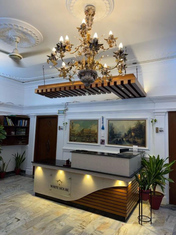 a lobby with a chandelier and a reception desk at White House Karachi in Karachi