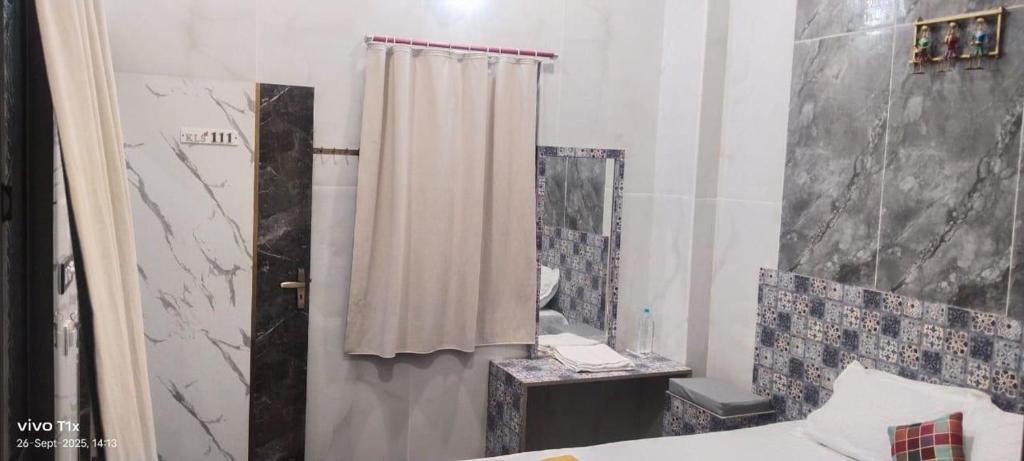 a bathroom with a shower curtain and a mirror at KLS Oceanic in Chennai