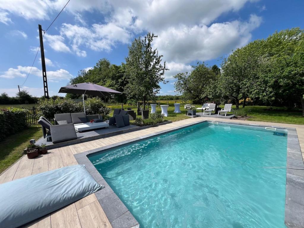 ein Schwimmbecken mit Stühlen und einem Sonnenschirm in der Unterkunft Propriété à la campagne in Rièzes