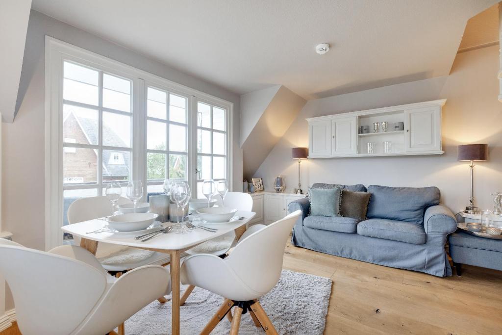 a living room with a table and chairs and a couch at Wattküken in Munkmarsch