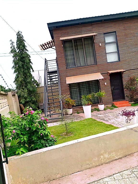 a house with a staircase in the front yard at Kalo Shipping Container in Christiansborg