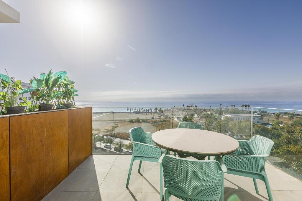 einen Tisch und Stühle auf einem Balkon mit Blick auf den Strand in der Unterkunft A&N La Vega 26, Torre del Mar in Almayate Bajo