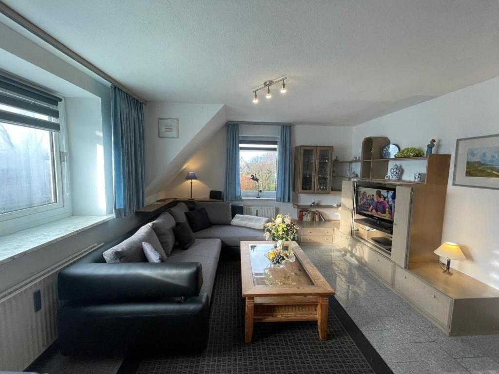a living room with a couch and a coffee table at Fewo 4 OG Sylt Westerland in Süderende