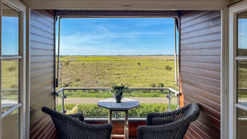 d'un balcon avec une table et des chaises et une vue sur un champ. dans l'établissement Heefwai 2 - W4, à Morsum