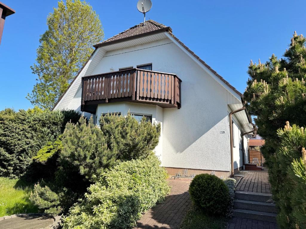 Una casa blanca con un balcón encima. en Baltique - Ferienwohnung 2 Glowe, en Glowe
