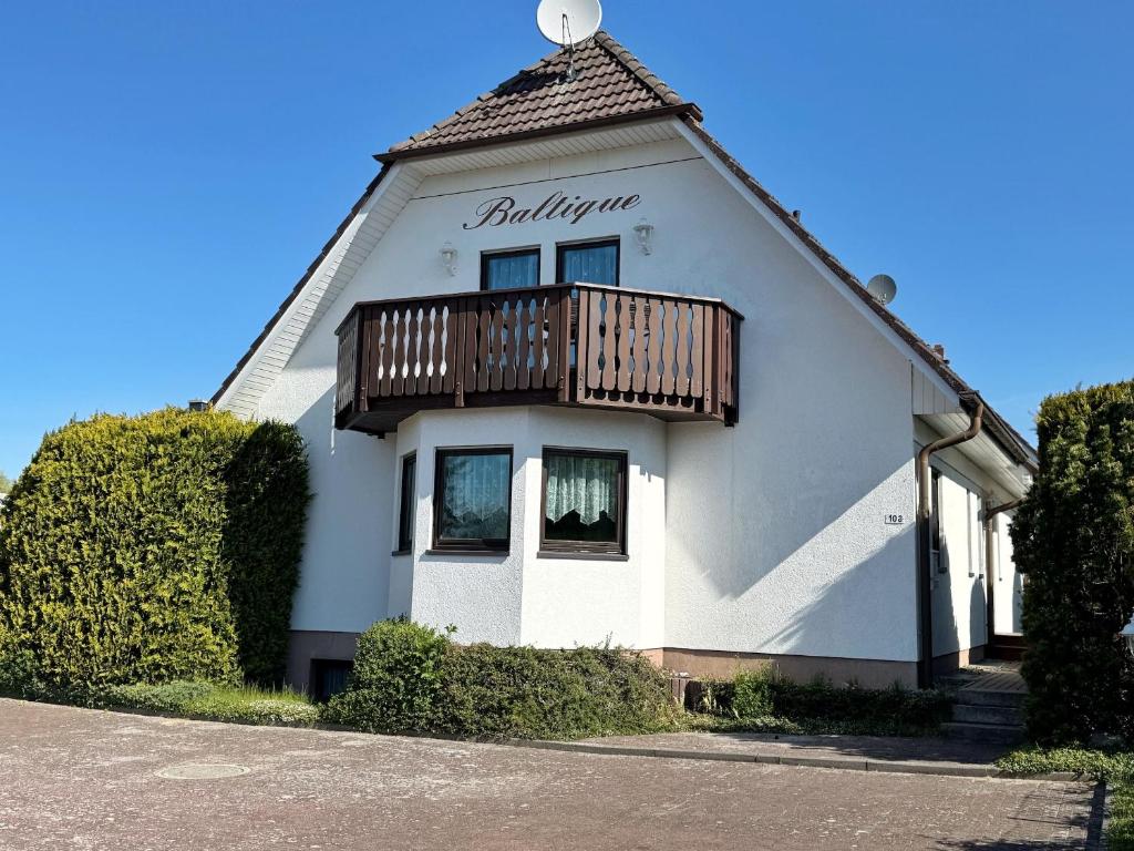 Un edificio blanco con un balcón en la parte superior. en Baltique - Ferienwohnung 3 Glowe, en Glowe