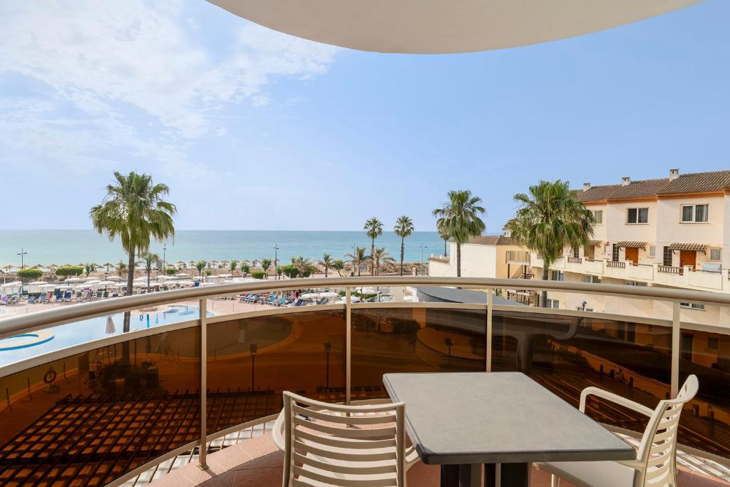 un balcón con mesa y sillas y la playa en Peñiscola Plaza Suites, en Peñíscola