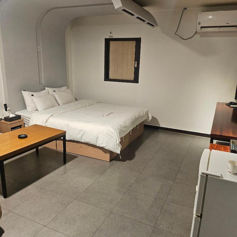 a bedroom with a bed and a table in it at Guri C Boutique Hotel in Guri