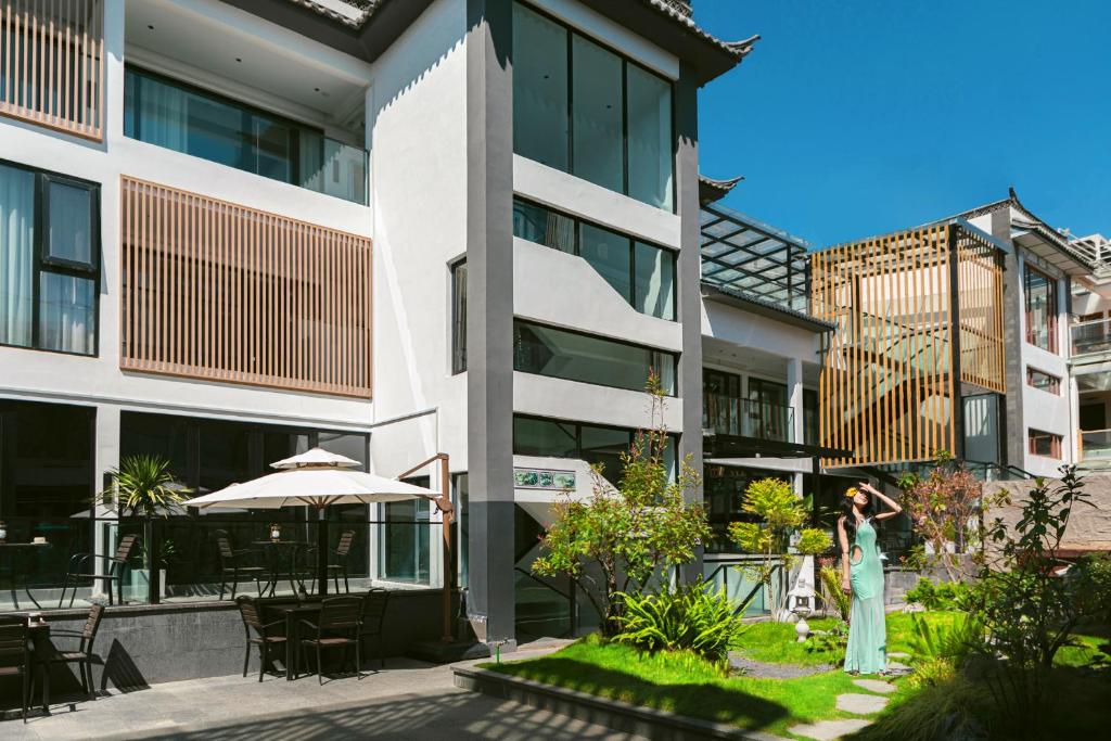 a woman standing in front of a building at Jingjie Garden Holiday Homestay in Dali