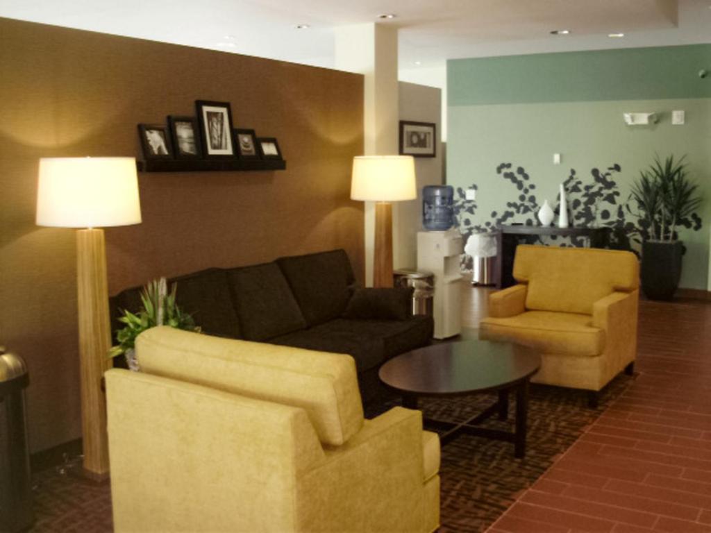 sala de estar con sofá, 2 sillas y mesa en Sleep Inn & Suites East Syracuse en East Syracuse