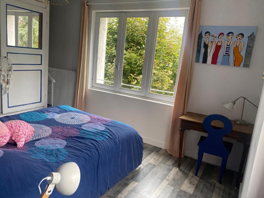 a bedroom with a bed and a blue chair and windows at Chambre dans villa les terrasses in Oullins