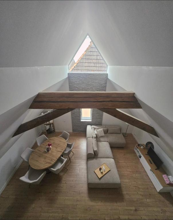 a room with a table and a couch and a table at Duplex sous les toits d'Alsace in Dannemarie