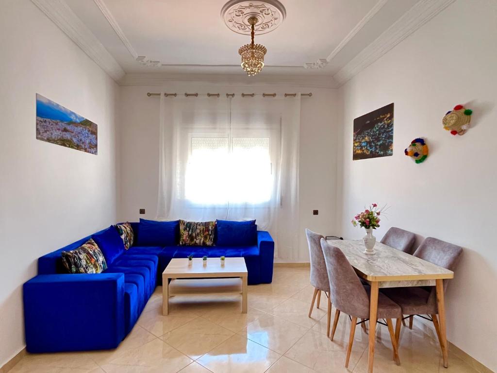 a living room with a blue couch and a table at Chauen White Pearl Apartments in Chefchaouene