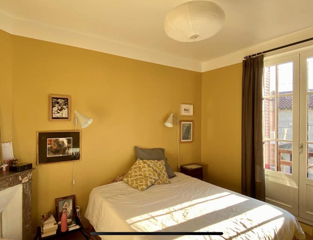 una camera da letto con un letto e una finestra di Maison avec jardin, à deux pas du centre-ville a Clermont-Ferrand